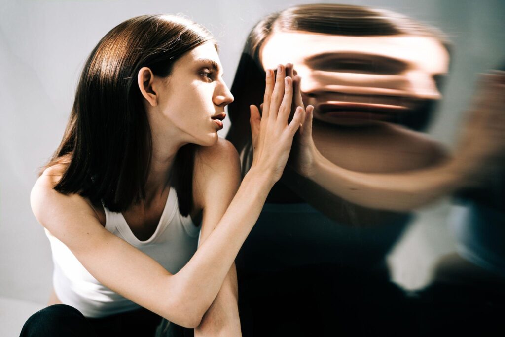 Pessoa diante de um reflexo distorcido, representando a construção da própria identidade.